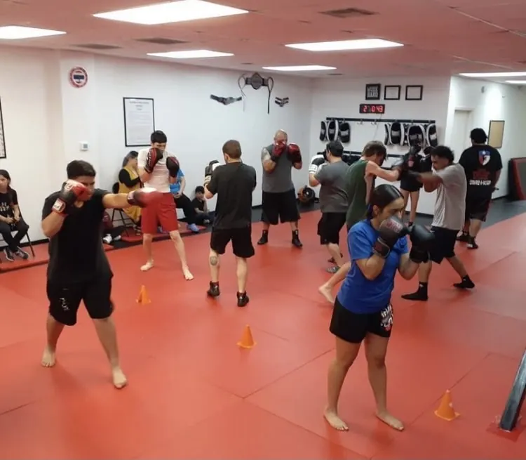 Men and women of different ages practicing their guard in a group class
