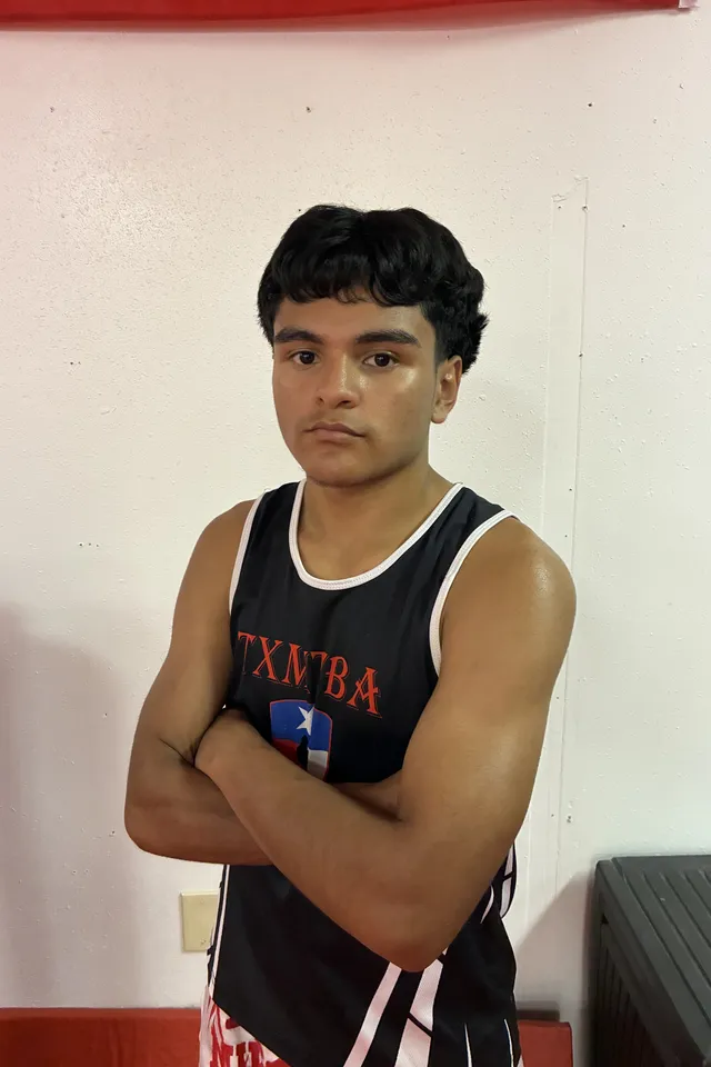 Coach Alexis Silva, arms crossed, in a black TXMT tank
